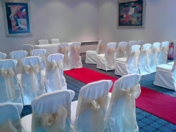 Gold organza sashes with white chair covers at The Holiday Inn Basildon