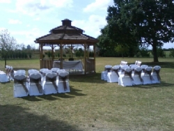 Brown organza sashes with white chair covers at The Old Rectory