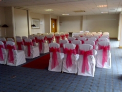 Pink organza sashes and white chair covers and sashes at The Holiday Inn Basildon